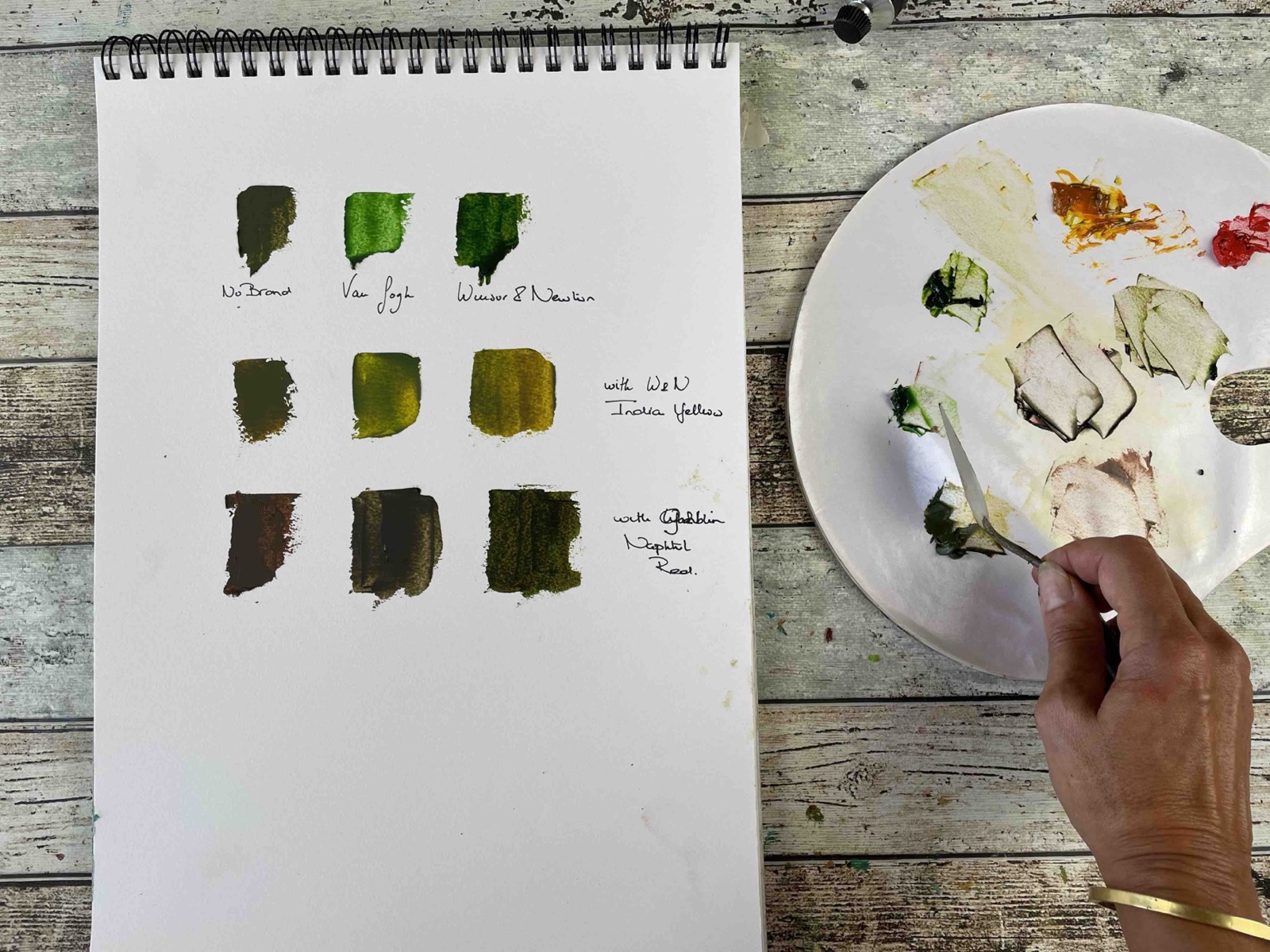 Marina mixing green paints at her studio table