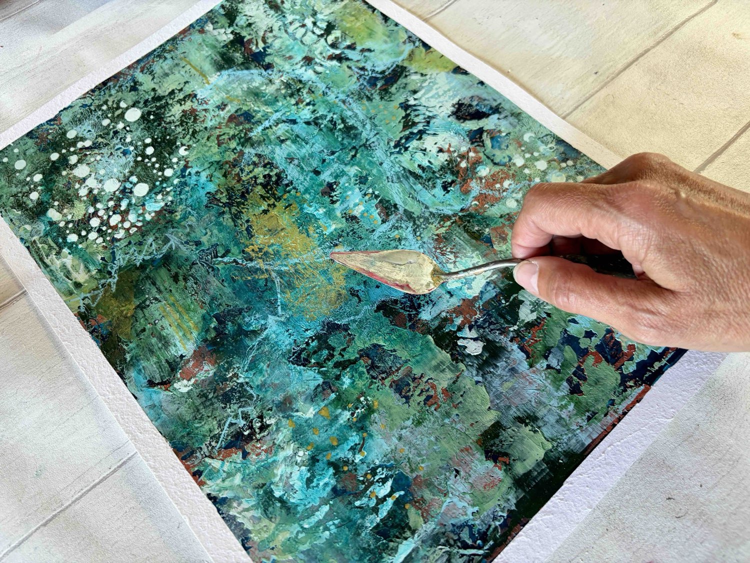 Close-up of a textured cold wax and acrylic surface, gold being worked in with a palette knife